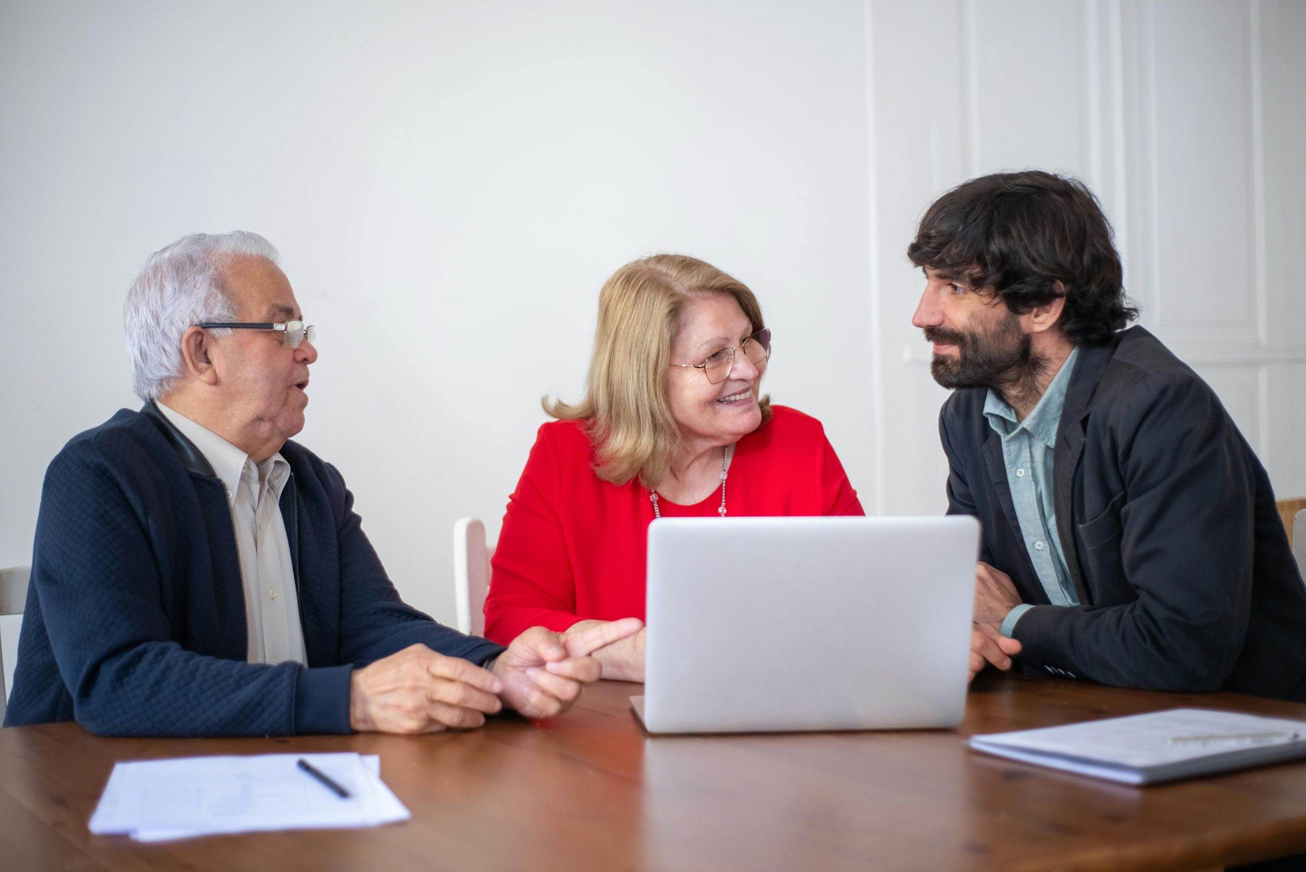 Elderly couple having a consultation with a professional advisor in a bright indoor setting.
